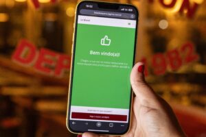 Mão mostra celular comparando Reservas WhatsApp x Tagme