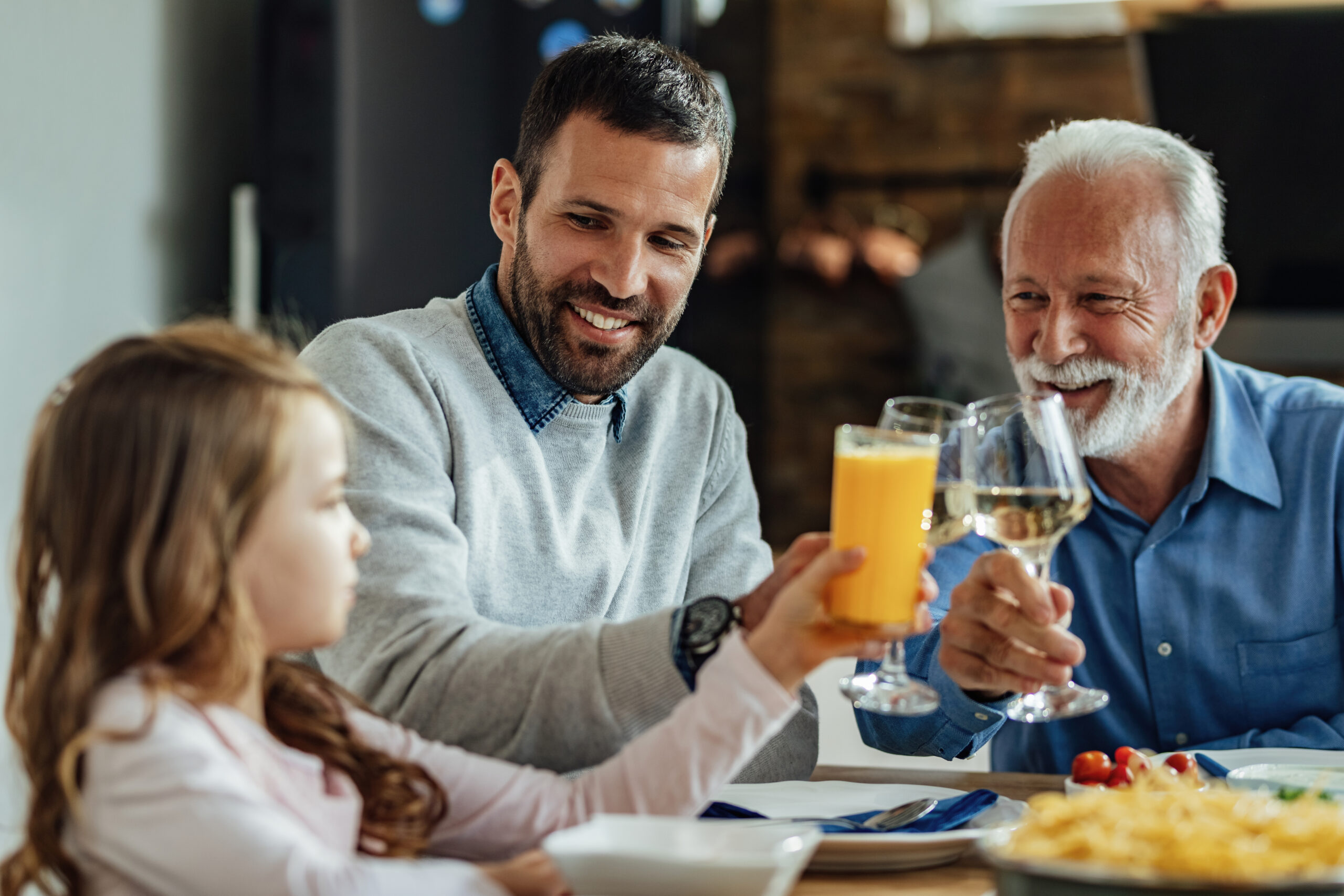 Família feliz brindando no dia dos pais e comprovando a eficácia de um bom marketing para restaurantes