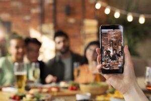 Pessoa fotografa amigos em um restaurante instagramável, com decoração aconchegante e clima descontraído
