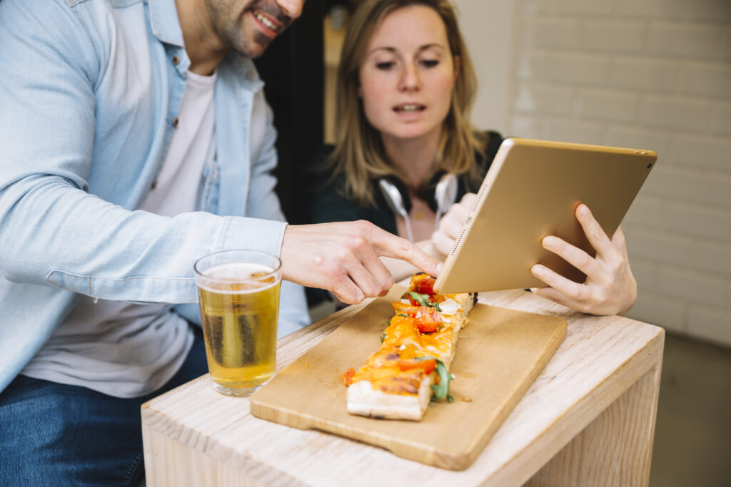casal em mesa de bar definindo um plano de marketing para restaurante