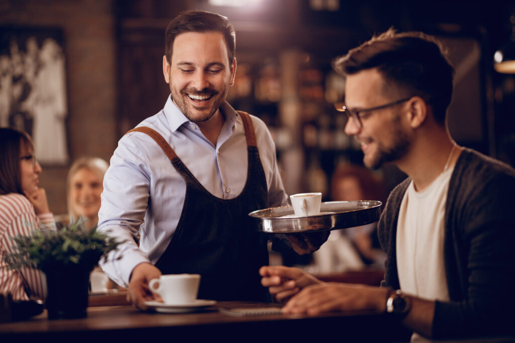 Garçom servindo clientes e demonstrando hospitalidade no foodservice