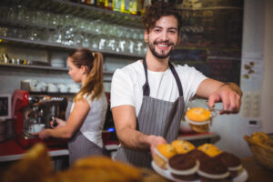 Barista sorrindo faz parte de uma equipe motivada