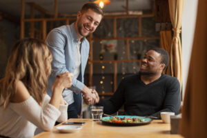 Cliente cumprimenta o garçom no restaurante, representando fidelização de clientes.