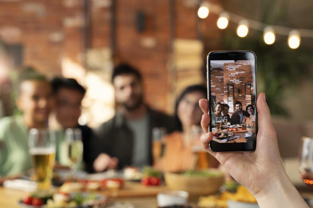 Pessoa fotografa amigos em um restaurante instagramável, com decoração aconchegante e clima descontraído